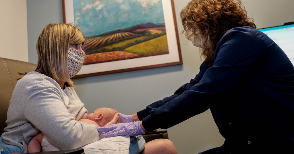 woman getting assistance with breastfeeding