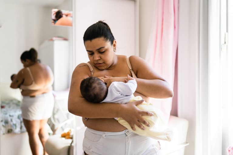 Mother breastfeeding baby in nursery.