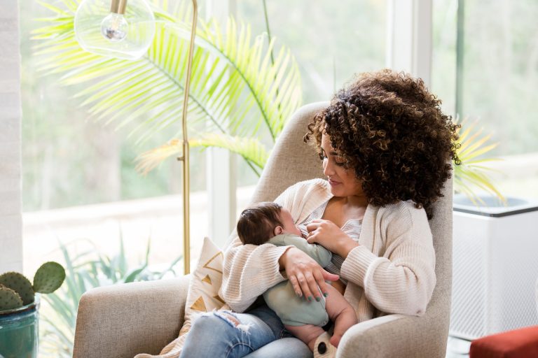 Mom nurses baby in nursery.