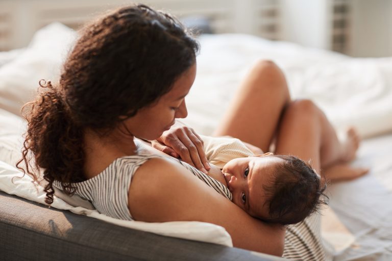 A mother breastfeeding baby boy using the cradle hold.