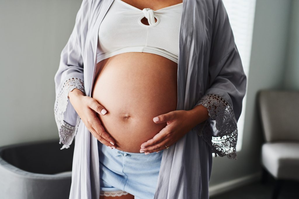 Cropped shot of an unrecognizable woman touching her pregnant belly