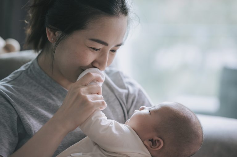 A mother bonding with her baby toddler at home.