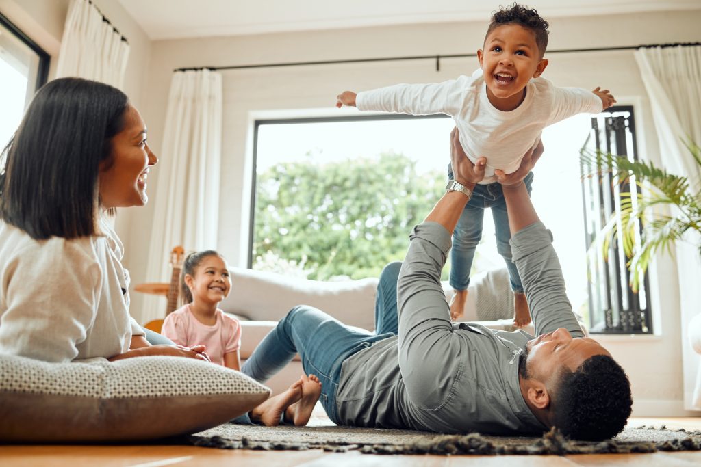 Shot of a young family playing together on the lounge floor at home