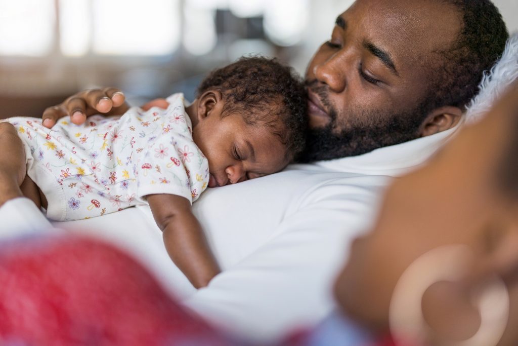 Father holding his baby in arms at home