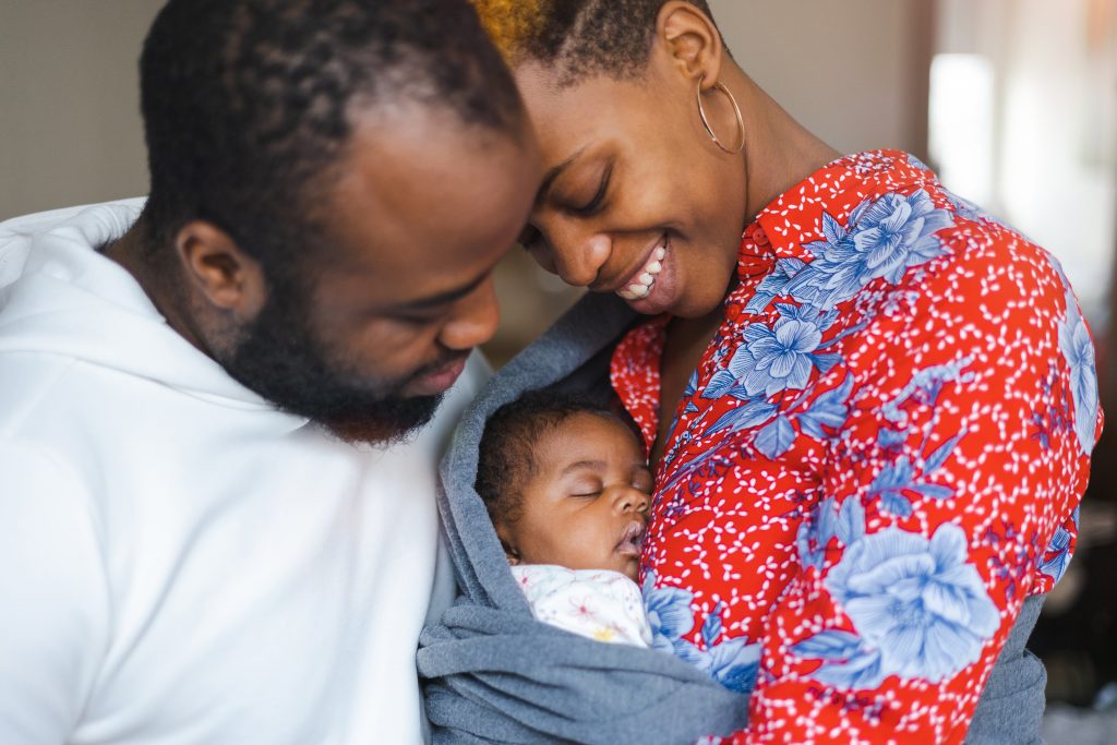 Young parents with their baby girl at home