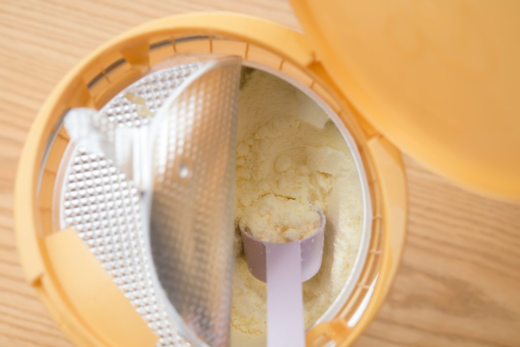can of powdered milk for children on wooden table close up