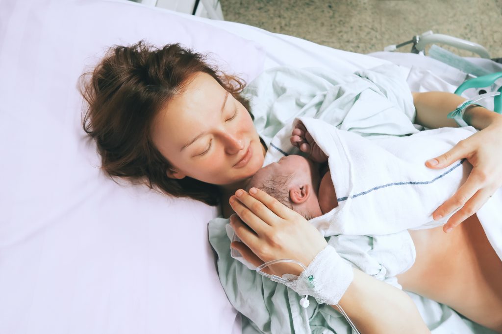 mother holding infant in first moments of bonding.