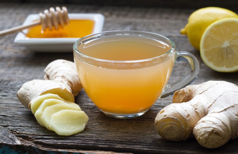 Ginger homemade tea infusion on wooden board with lemon still life