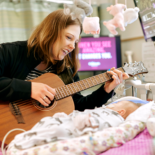 Erinn Frees, MA, MT-BC, board-certified music therapist at Children’s Minnesota, helping a patient