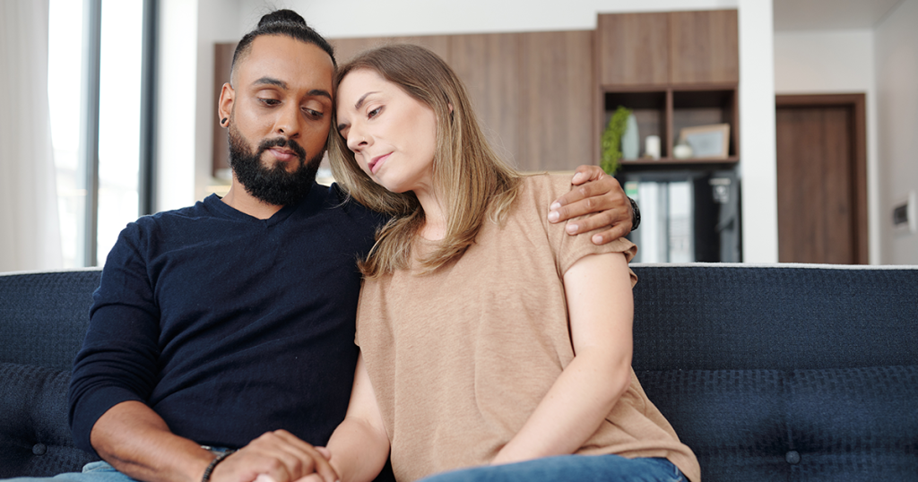 a couple on the couch grieving a miscarriage
