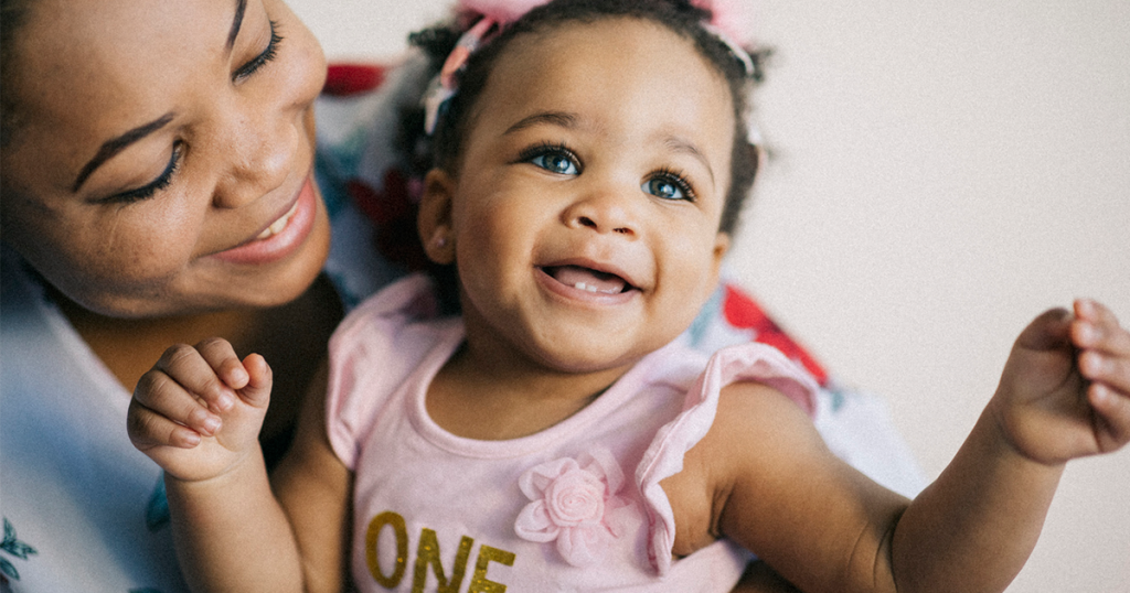 Caring young mother and her 1-year-old baby girl having fun together.