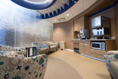 Photograph showing a waiting area at the St. Paul location. Image shows several chairs, a microwave, a coffee station and a counter.